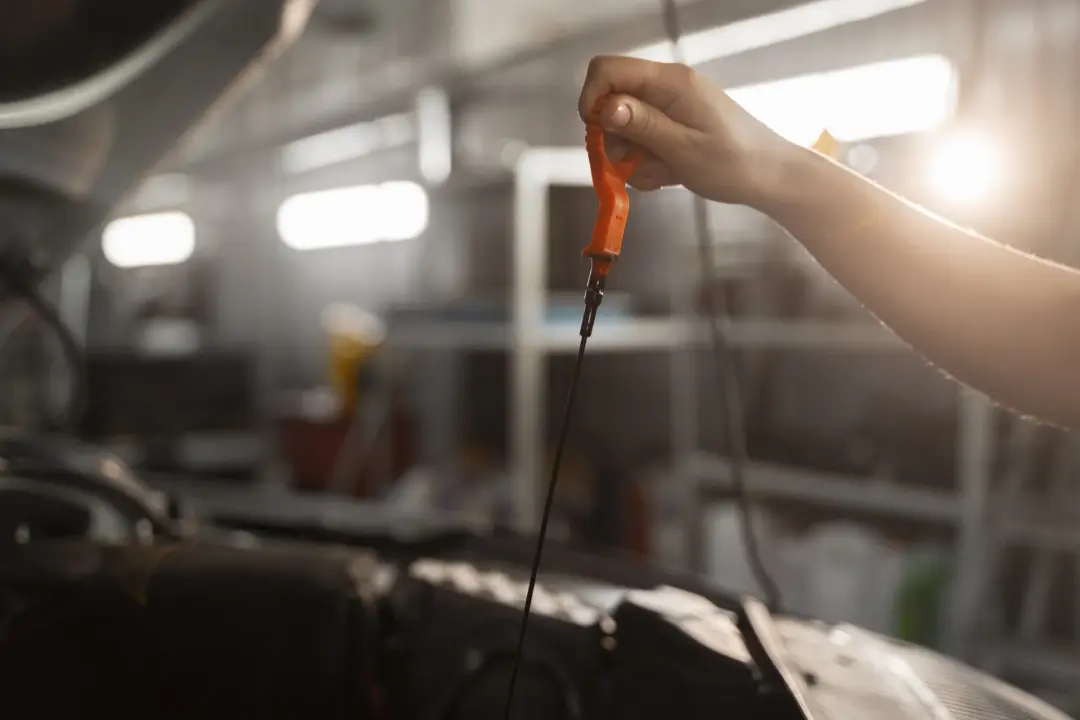 Engineer pulling an oil dipstick to check the level