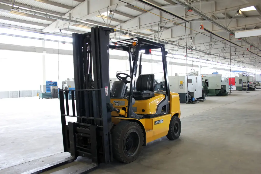 New yellow counterbalance forklift standing in a bright, empty hall