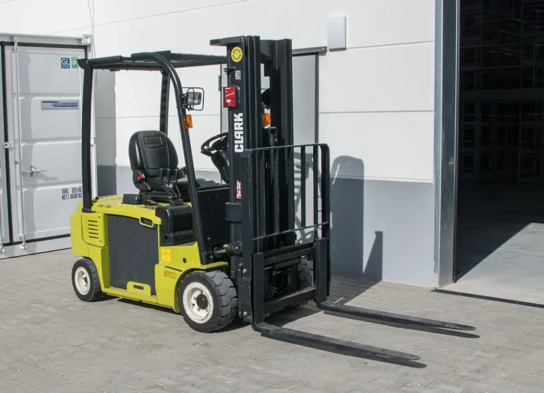 Orange counterbalance forklift standing in an outdoor yard